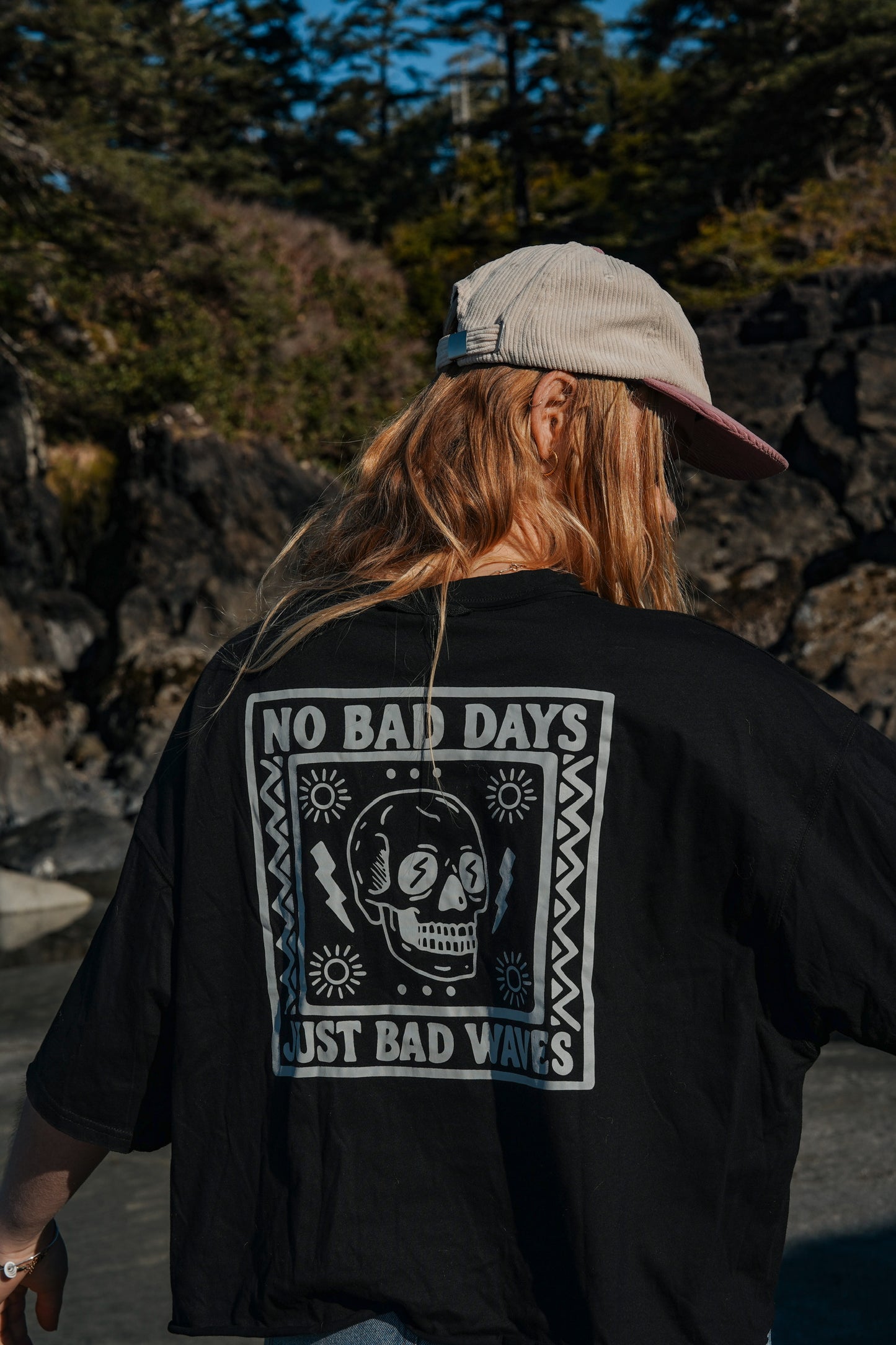 Woman wearing black cotton graphic tee with relaxed fit at the beach