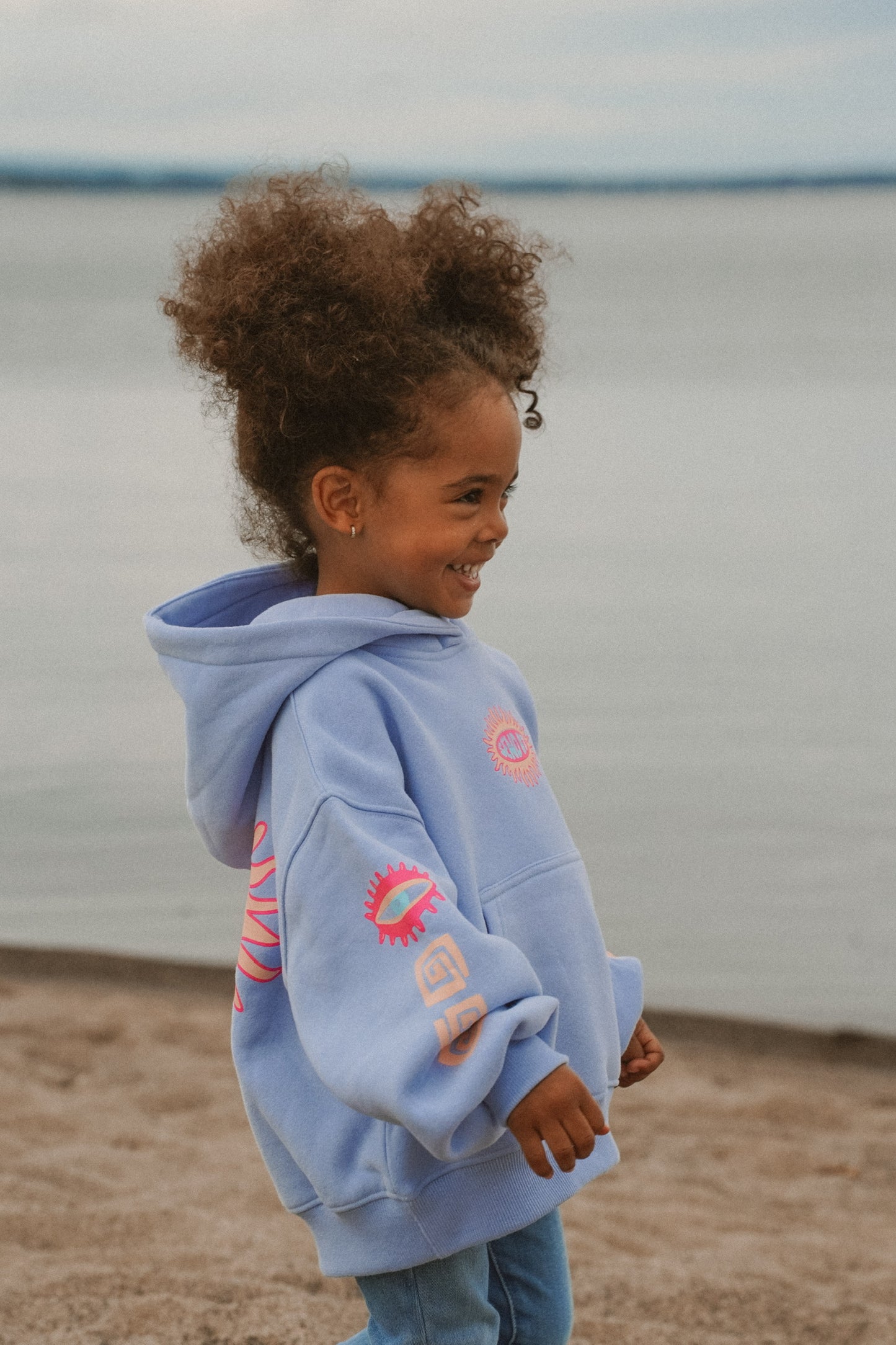Child wearing blue cotton oversized hoodie with Send It print in a summer style