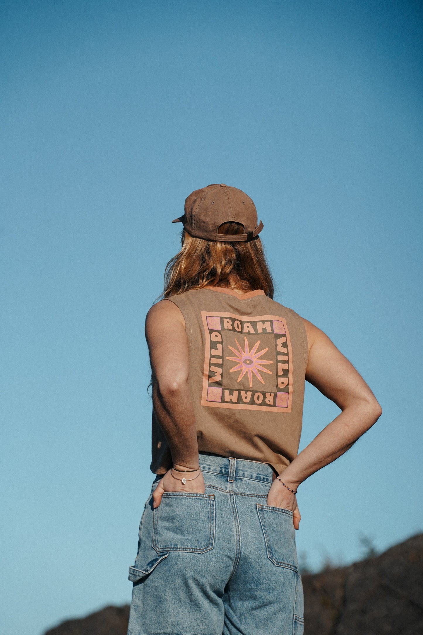 Woman wearing brown cotton tank top with relaxed fit and graphic print