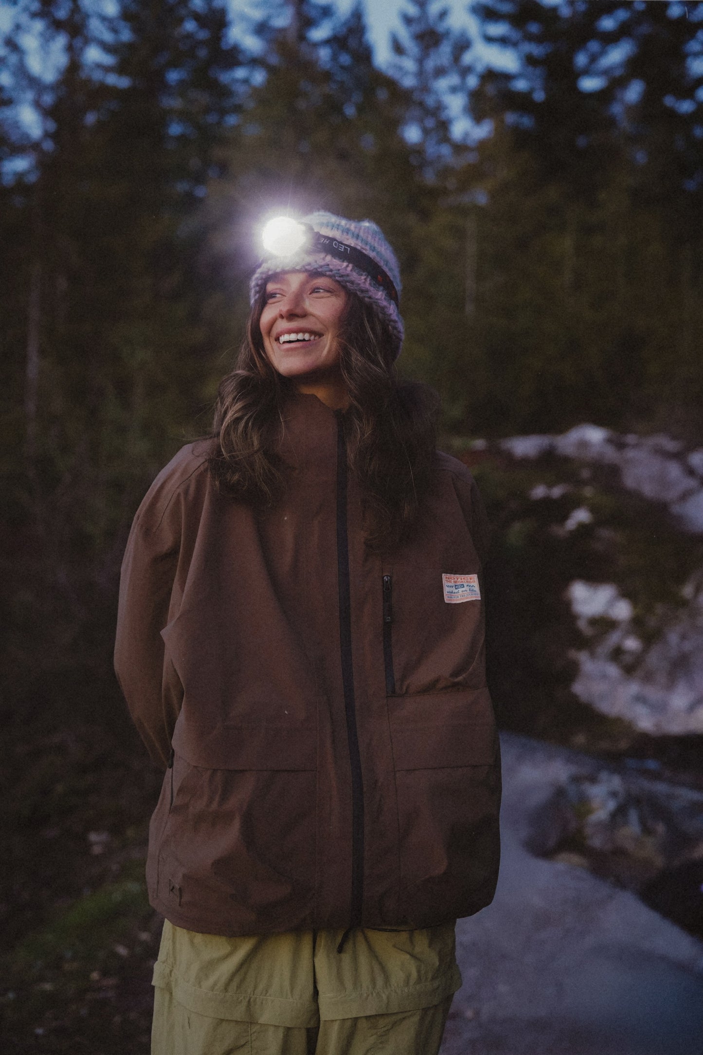 Women's espresso waterproof rain jacket worn outdoors