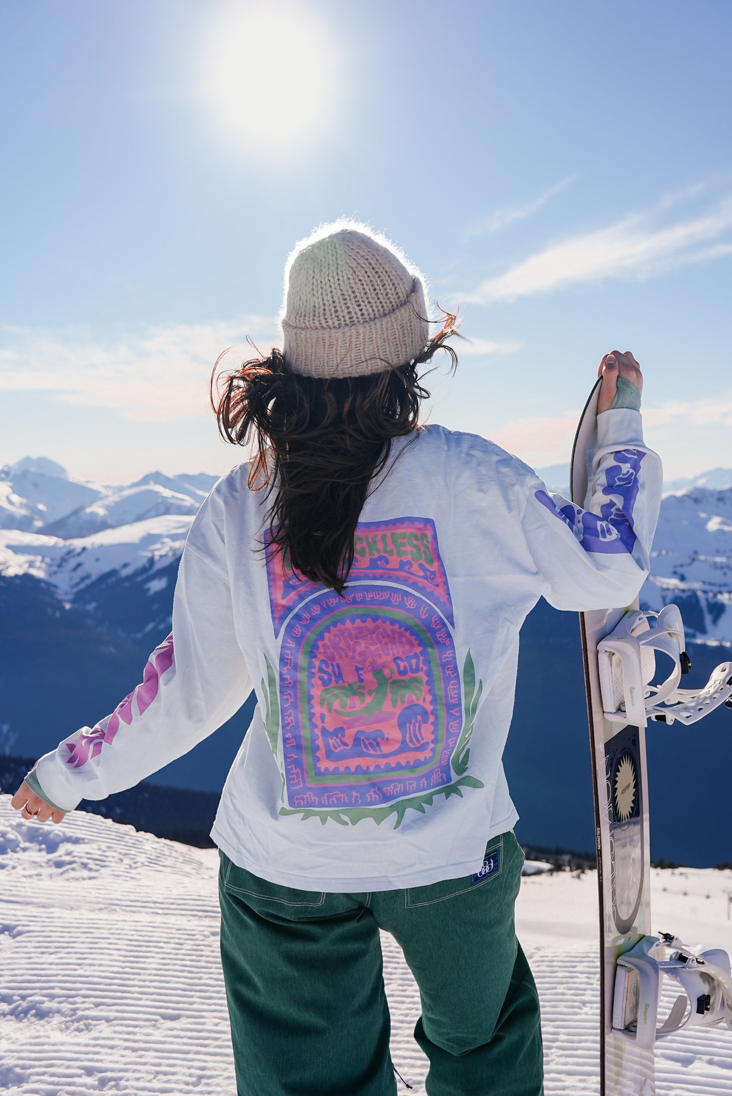 Women’s white oversized cotton long sleeve shirt with large back graphic and sleeve prints, styled for outdoor and mountain adventures