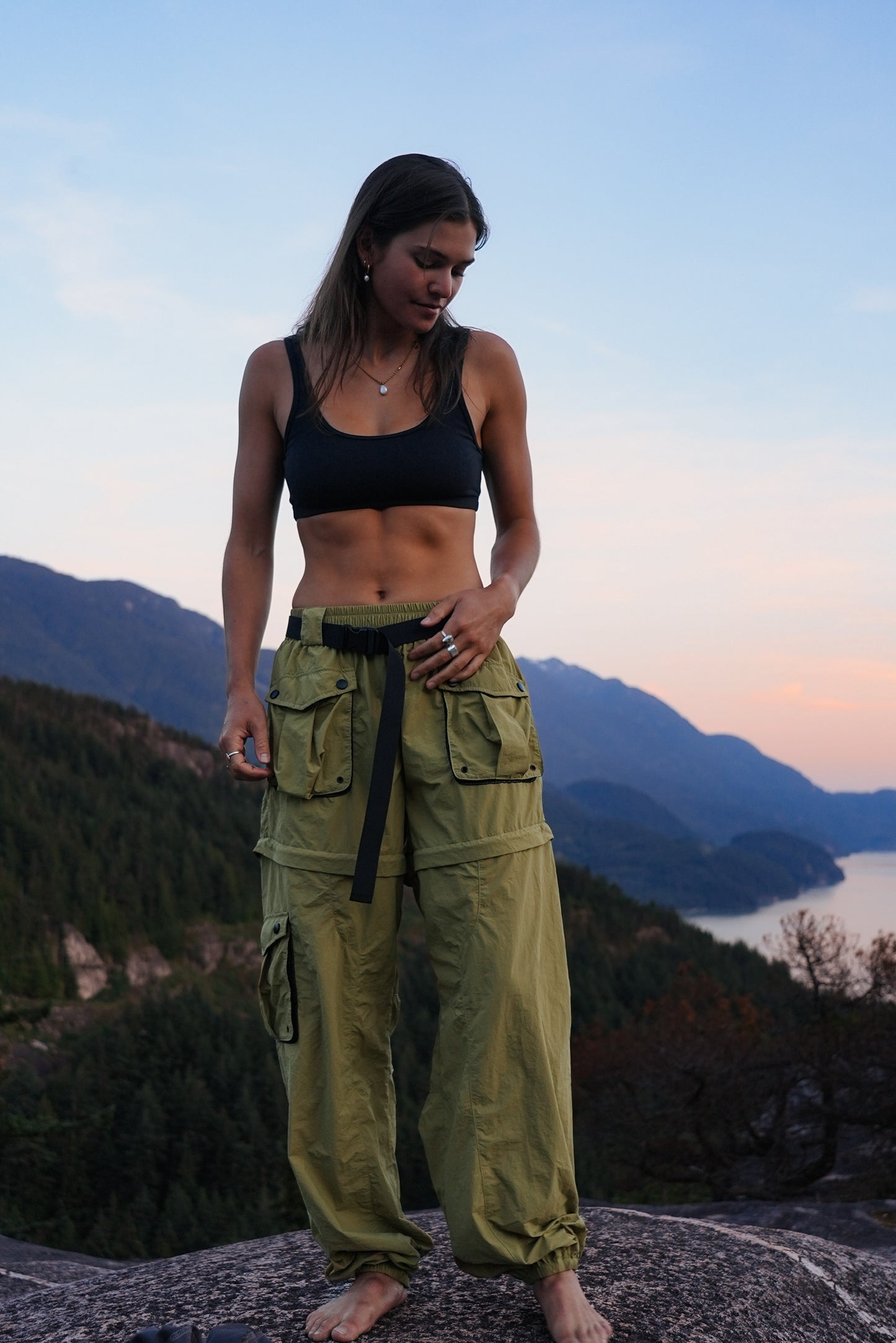 Women's khaki zip-off hiking pants with cargo pockets and adjustable waistband worn outdoors