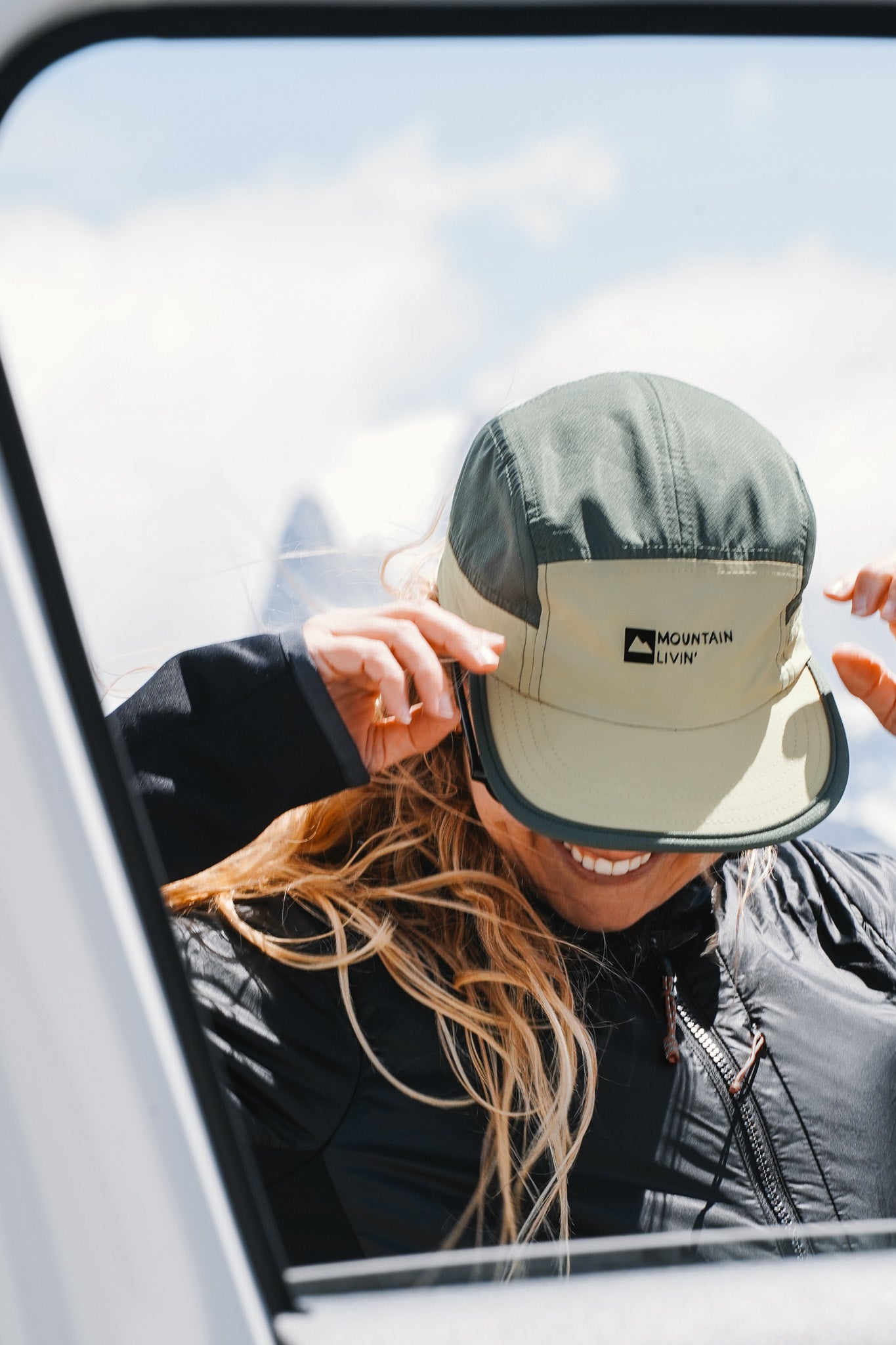 Mountain Livin 5-panel hiking cap in green and khaki worn outdoors with front logo patch