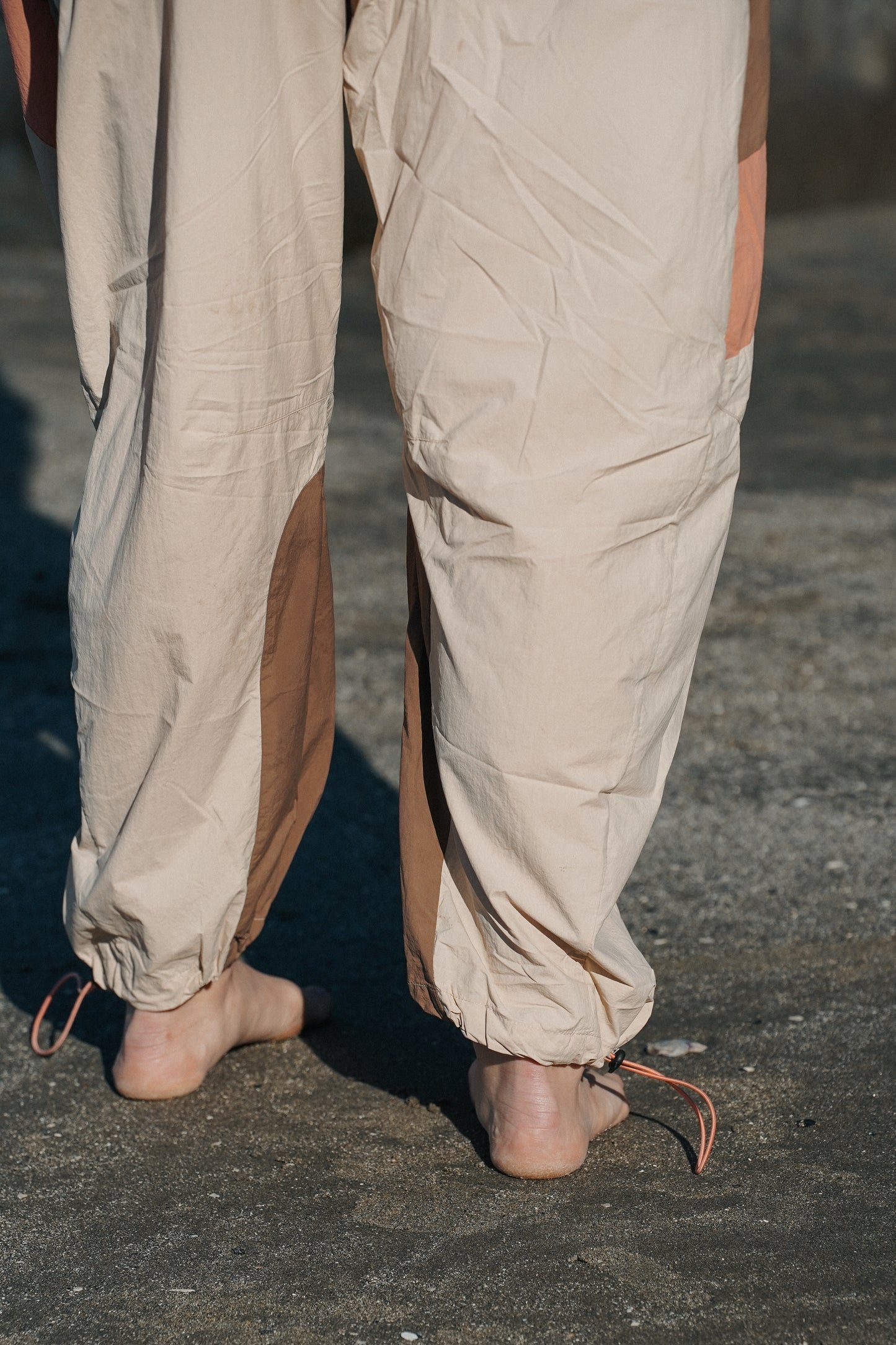 Relaxed-fit Mountaineer hiking pants with durable reinforced knees, cord-lock ankle hems and soft neutral earth-tone colors for mountain hiking and outdoor exploration