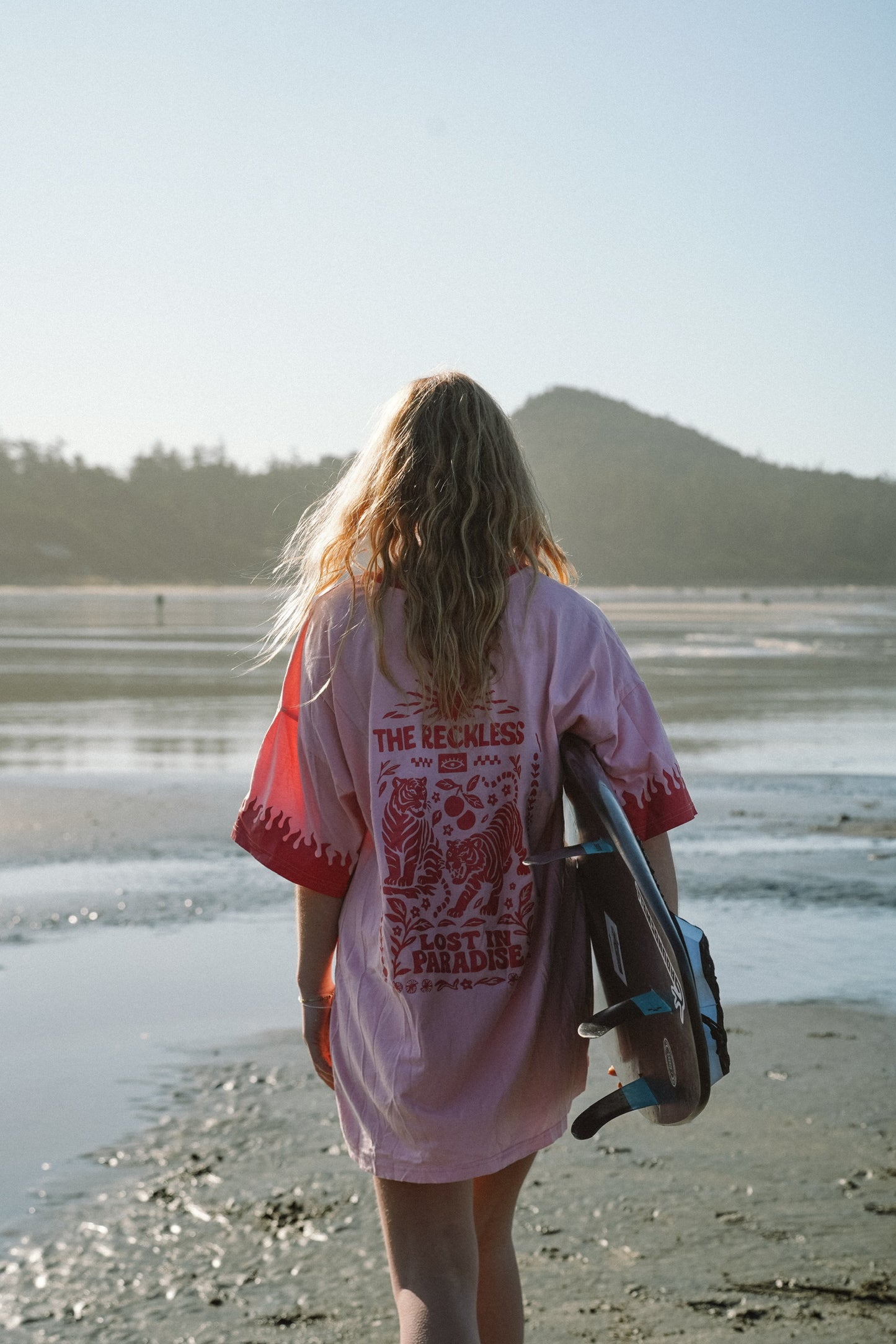 Woman wearing pink cotton long sleeve tee dress with relaxed fit and graphic design