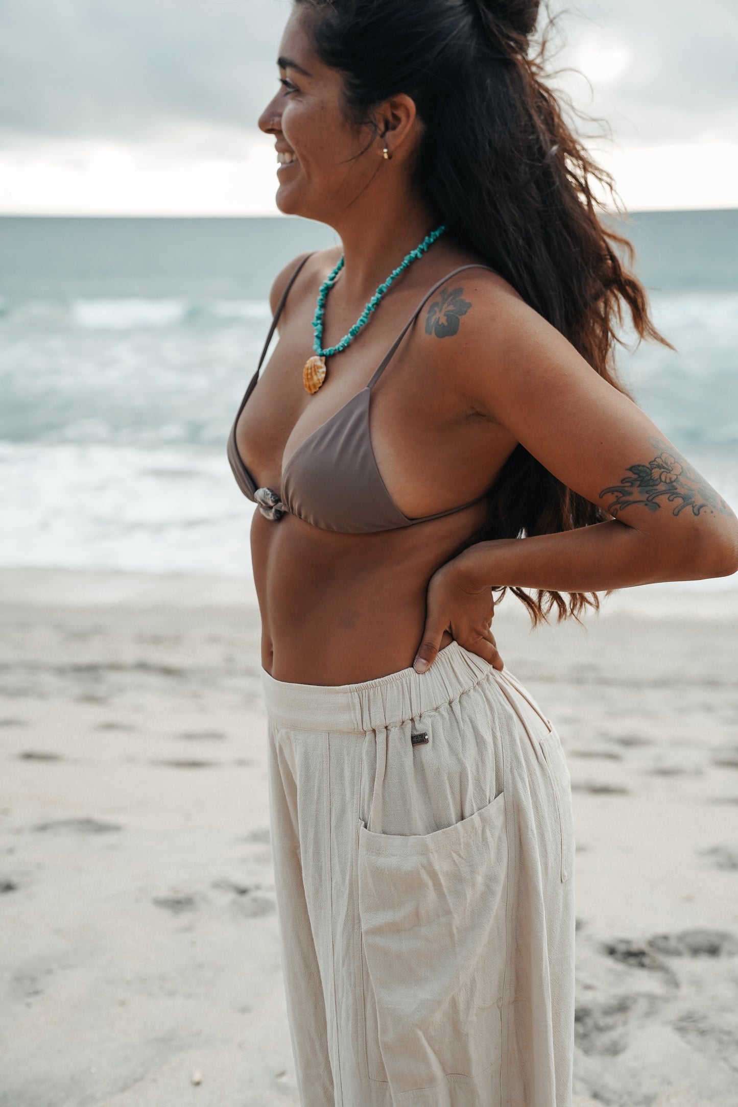 Sand linen barrel pants featuring an elastic waistband, two large side pockets and a back pocket, captured with an effortless coastal vibe