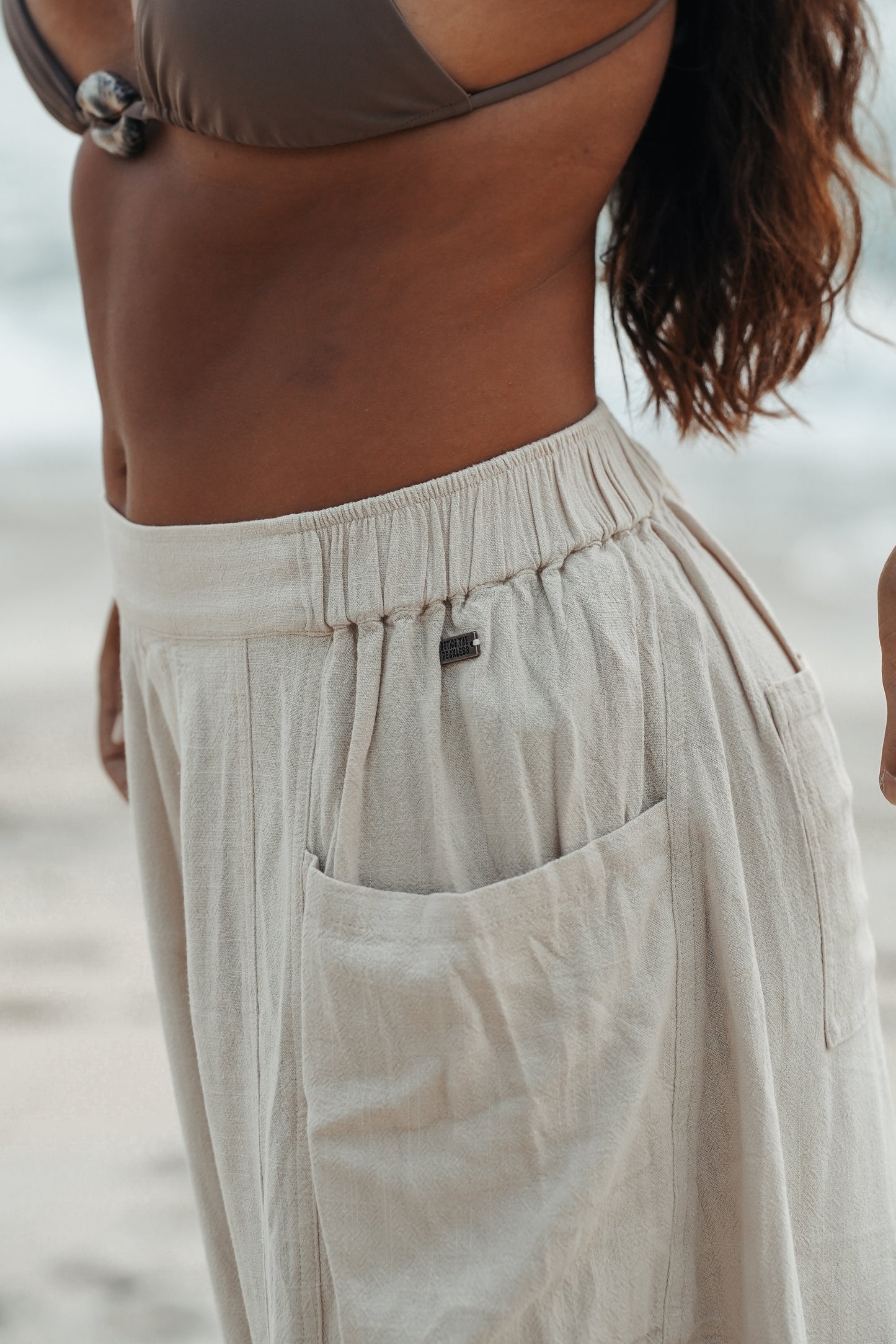 Women's wide-leg linen barrel pants in a soft sand hue, designed for breathable comfort and easy resort-inspired styling