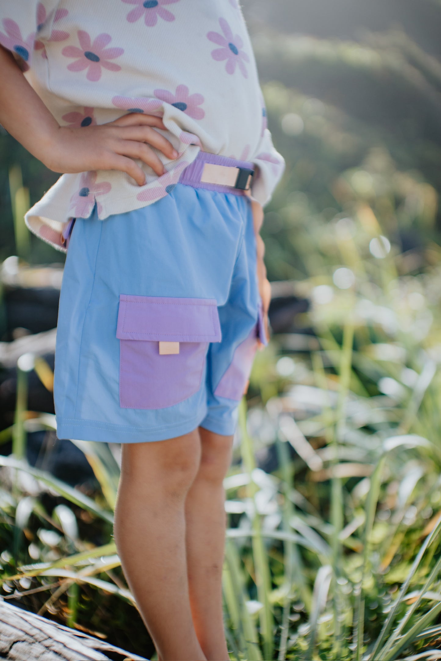 Kids Tide Trek shorts in blue with purple patch pockets and adjustable waistband