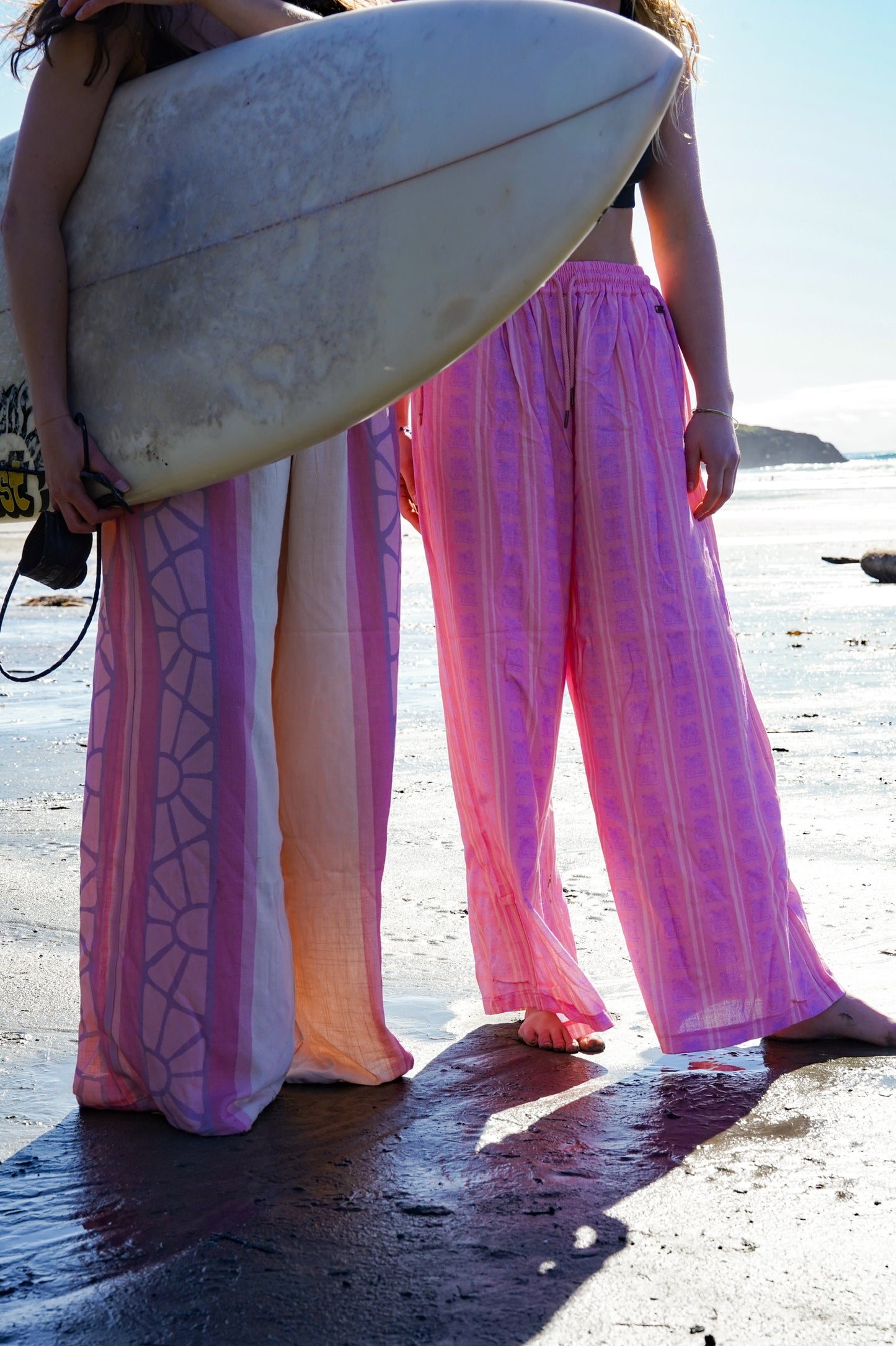 Colorful cotton boho pants with pink, coral, and purple pattern designed for summer and surf lifestyle