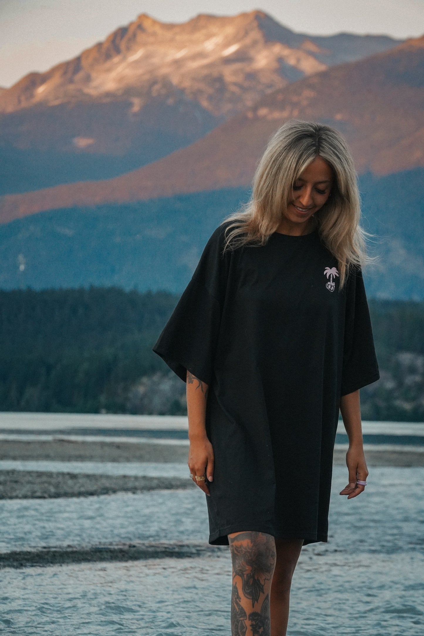 Woman wearing black cotton tee dress with Sponsored by Bad Decisions design and relaxed fit