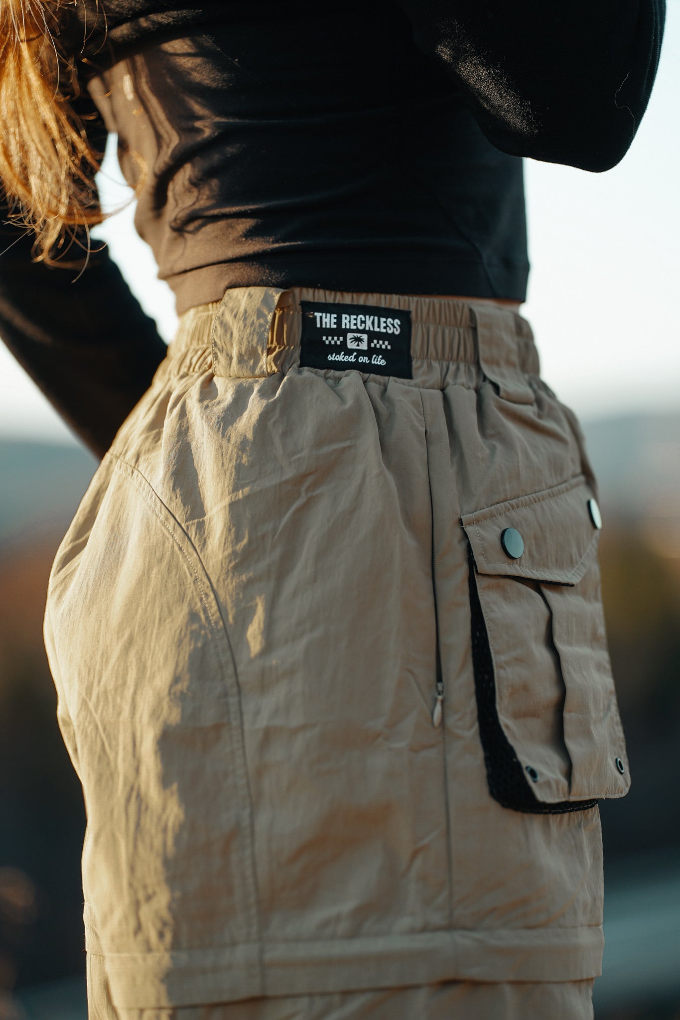 Women’s sand khaki utility zip-off pants featuring large cargo pockets, adjustable waist and detachable legs for outdoor adventures and casual streetwear